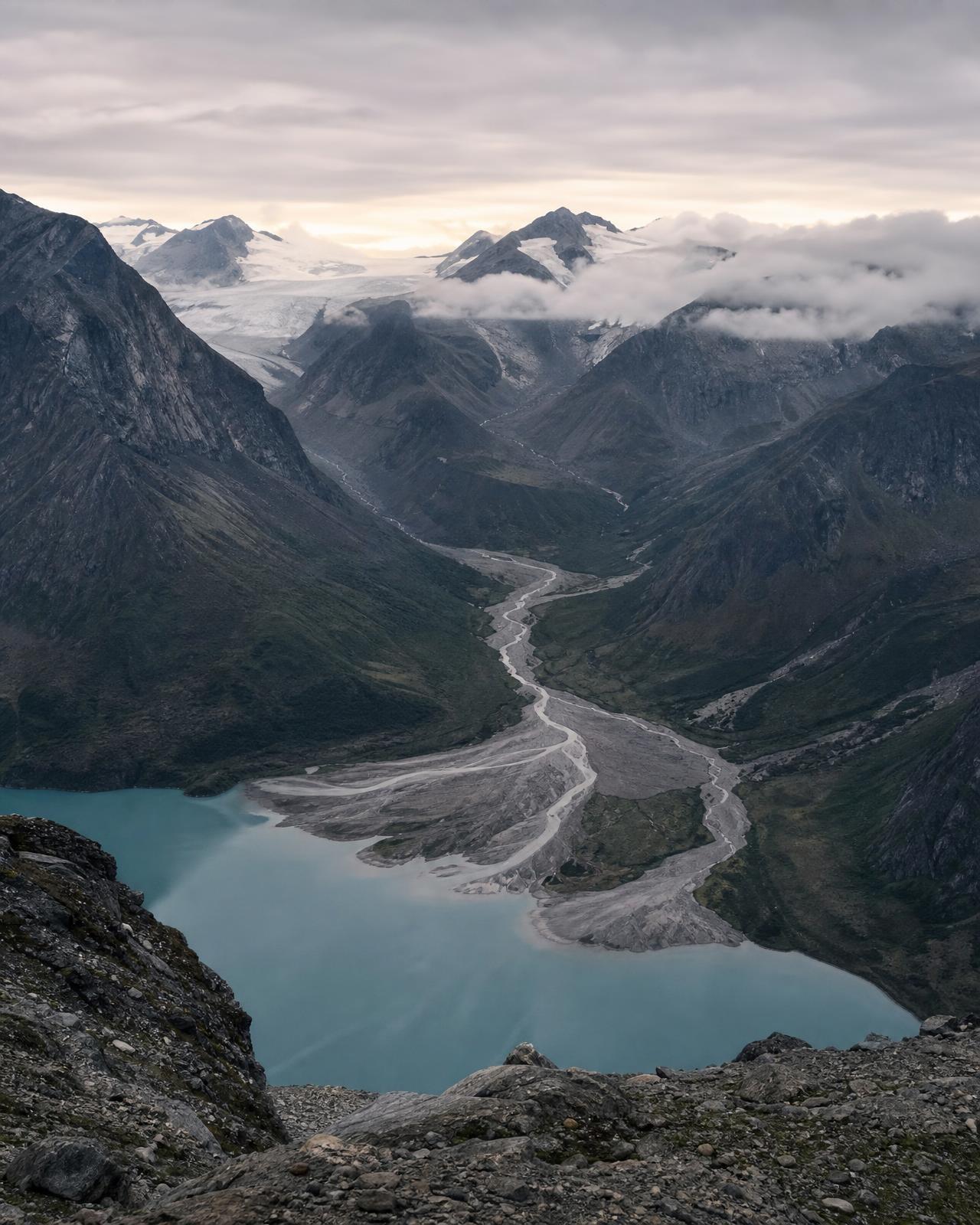 Mountain tributaries converging into a blue glacial lake